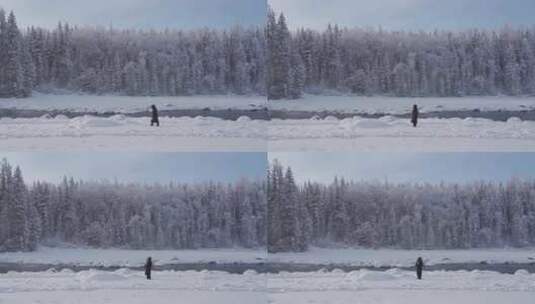女人走在大雪覆盖的新疆喀纳斯河边高清在线视频素材下载