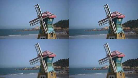 蓝蓝的天空下大海的边上一个木制的风车高清在线视频素材下载