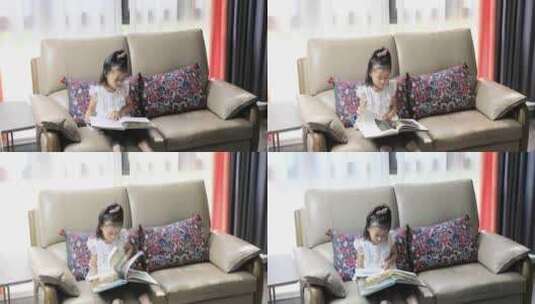 小女孩坐在沙发上看书高清在线视频素材下载