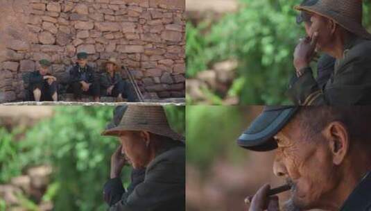 乡下老农视频农村石头墙下休闲抽烟的农民高清在线视频素材下载