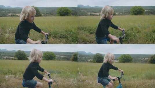 可爱的快乐儿童男孩在乡村公路上骑自行车高清在线视频素材下载