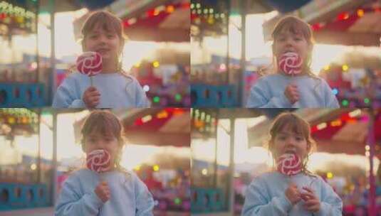 可爱小女孩吃棒棒糖在游乐园高清在线视频素材下载
