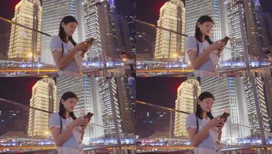 夜晚女孩在城市街头看手机 -使用手机高清在线视频素材下载
