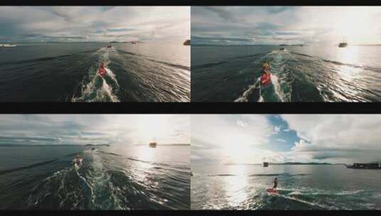 FPV航拍快艇拉着少年玩水上滑板日出四王岛高清在线视频素材下载