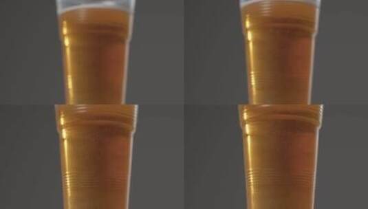 滑动拍摄接近塑料杯啤酒高清在线视频素材下载