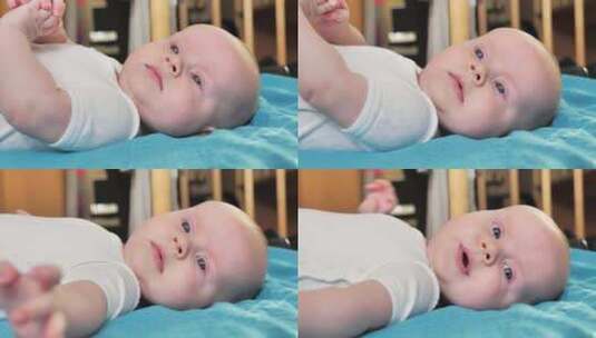 可爱的新生男婴仰卧在一张大床上的侧视图近高清在线视频素材下载