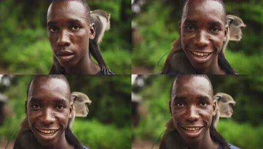 一个真实的非洲男人看着相机，抱着一只小猴高清在线视频素材下载