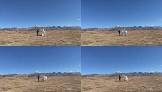 高原枯黄草原拍情侣走向雪山写真婚纱慢动作高清在线视频素材下载