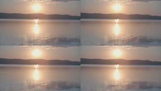 日落时男人在湖上划独木舟的远景高清在线视频素材下载