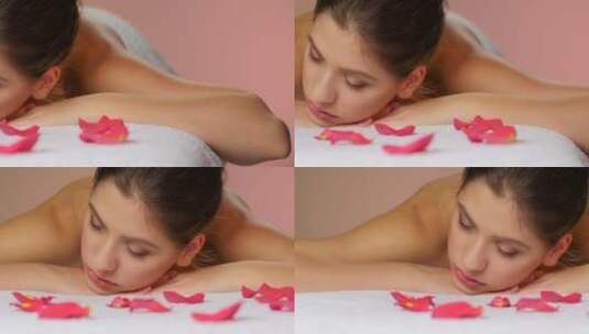 女孩放松的躺在玫瑰花瓣毛巾上高清在线视频素材下载