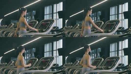 穿运动内衣的年轻女性在健身房使用跑步机高清在线视频素材下载