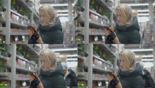女人在超市看手机高清在线视频素材下载