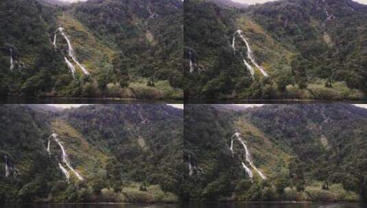 白天拍摄新西兰米尔福德湾峡湾的临时瀑布或瀑布范围。高清在线视频素材下载