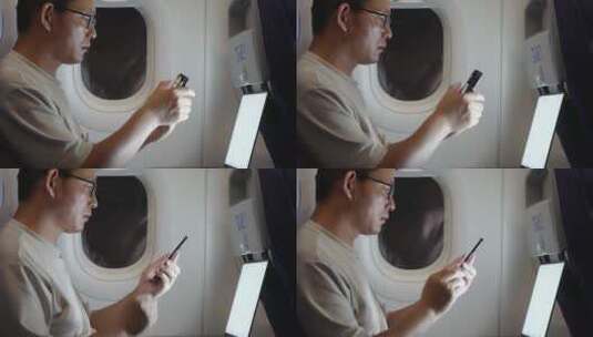 男子在飞机上使用手机和笔记本电脑高清在线视频素材下载