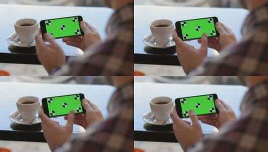 男子在咖啡馆滑动绿幕手机的特写高清在线视频素材下载