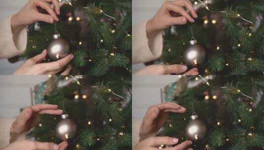 女人手在圣诞树上挂银球的特写镜头高清在线视频素材下载