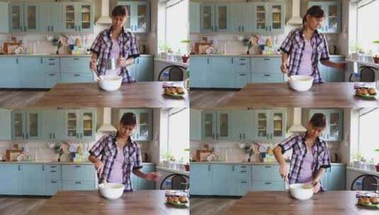 一个女人在家厨房准备食物，在碗里搅拌面团高清在线视频素材下载