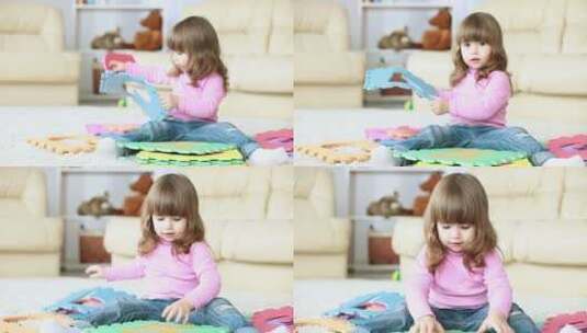 女孩坐在地毯上玩玩具高清在线视频素材下载
