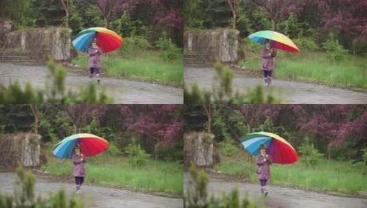 雨中打伞的小女孩在公园里玩耍高清在线视频素材下载