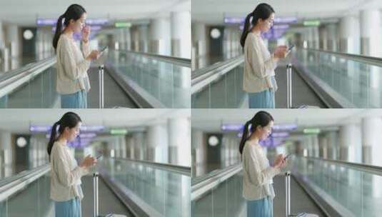 妇女在机场自动扶梯上使用手机高清在线视频素材下载