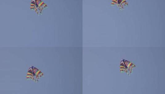 蓝天中飘飞的彩色条纹风筝高清在线视频素材下载