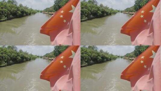 在湿地河流上航行的船红旗飘扬高清在线视频素材下载
