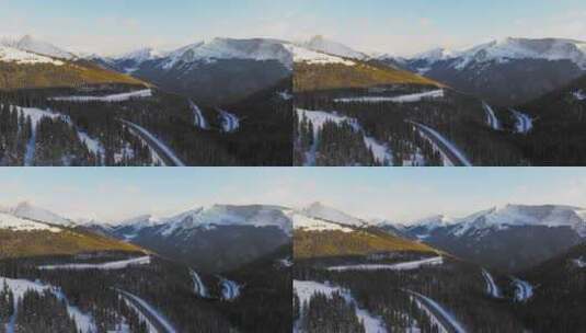 汽车行驶在森林公路上盘山路旅行自驾游雪山高清在线视频素材下载
