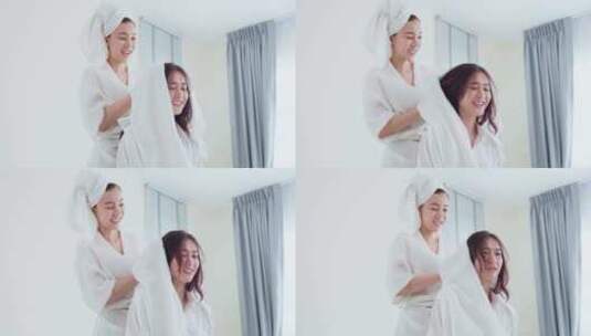 亚洲美丽的女同性恋夫妇在卧室里的床上淋浴后干燥女朋友的头发。高清在线视频素材下载