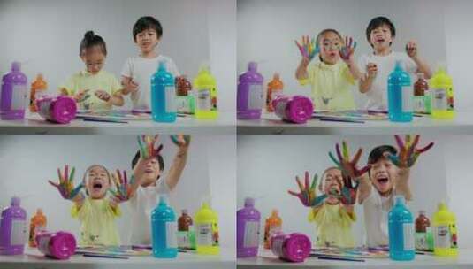 小男孩和小女孩用涂满颜料的手画画高清在线视频素材下载