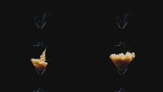 橙色液体被倒入水中的鸡尾酒杯中高清在线视频素材下载
