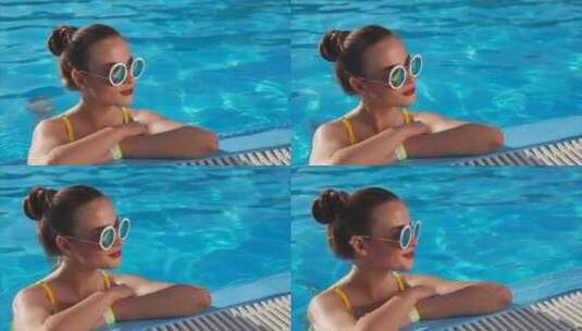 戴着太阳镜的年轻女子在游泳池里享受好天气晴天高清在线视频素材下载