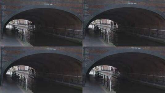 跟踪拍摄人们穿过运河边隧道高清在线视频素材下载
