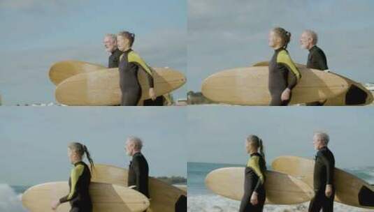 夫妇举着冲浪板跑向大海高清在线视频素材下载