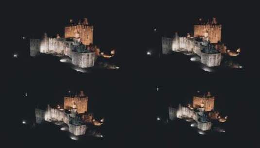 夜间空中航行在灯火通明的城堡建筑附近的船高清在线视频素材下载