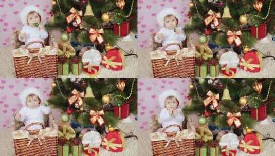 婴儿坐在圣诞树旁的小篮子高清在线视频素材下载