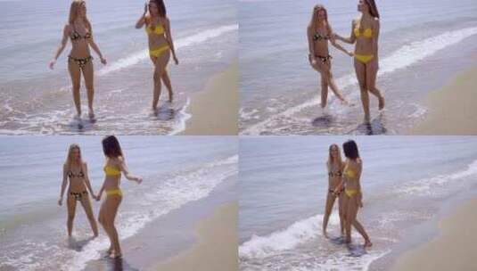 两个迷人的女人漫步在海滩上高清在线视频素材下载