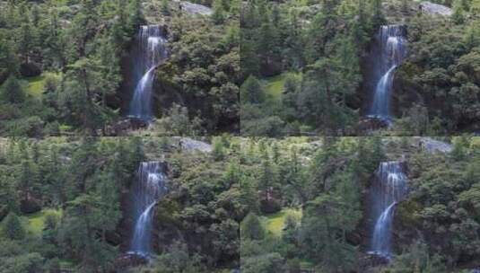 川西稻城亚丁山林树木间分流直下瀑布流水高清在线视频素材下载