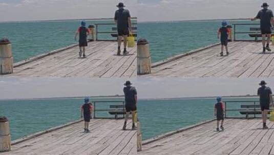 澳大利亚墨尔本海边木栈道钓鱼码头父子高清在线视频素材下载