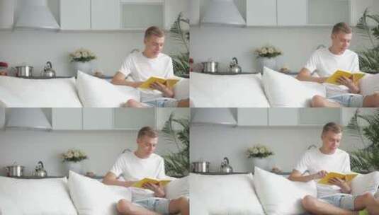 男人坐在沙发上看书高清在线视频素材下载