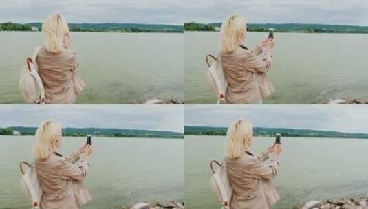 女人用手机拍摄湖泊全景高清在线视频素材下载
