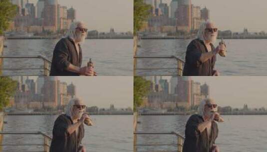 白发老人在河边喝酒高清在线视频素材下载