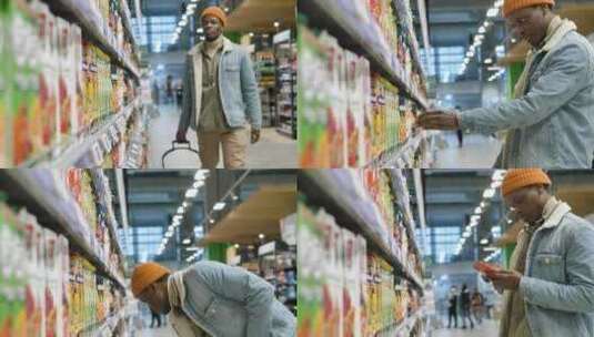 戴帽子穿夹克的非裔美国人在商店里选择果汁高清在线视频素材下载
