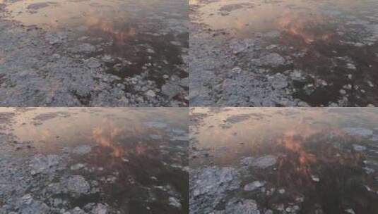 冰冻湖面上漂浮在冰层上的金色云彩的慢速空高清在线视频素材下载