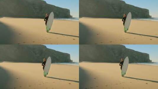 女孩拿着冲浪板站在沙滩上高清在线视频素材下载