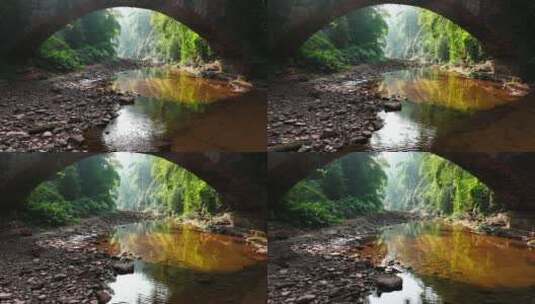 无人机穿越桥洞航拍山间竹林溪流高清在线视频素材下载