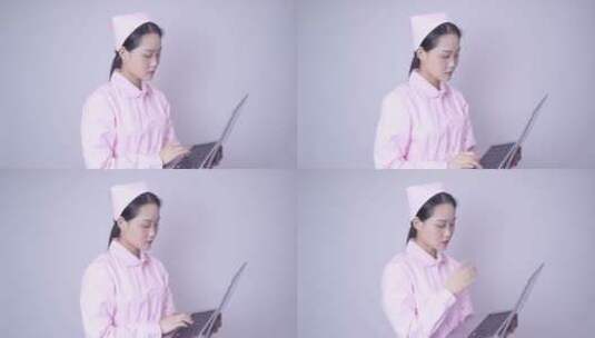 年轻女性医护形象手持笔记本电脑办公高清在线视频素材下载