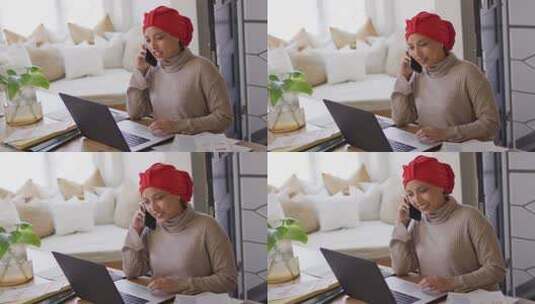 戴着头巾在办公桌上工作的微笑的混血女人在家用智能手机交谈的视频高清在线视频素材下载
