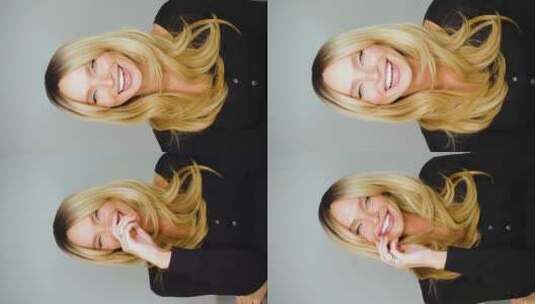 一个快乐大笑的美丽金发女人的垂直视频高清在线视频素材下载