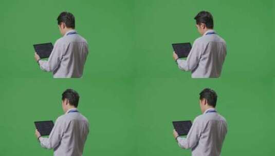 亚洲商人在绿屏背景前使用平板电脑高清在线视频素材下载
