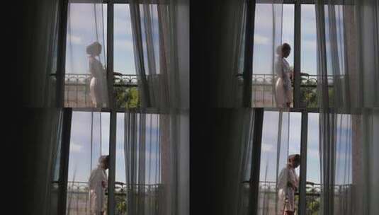 一个女人打开阳台的窗户，享受婚礼前的早晨高清在线视频素材下载